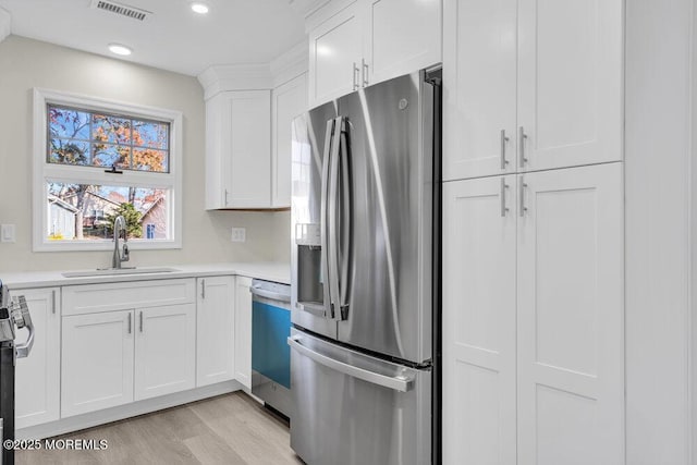 1396 Gleniffer Hill Rd, Toms River, NJ 08755 - kitchen with a sink, appliances with stainless steel finishes, light wood finished floors, white cabinetry, and visible vents