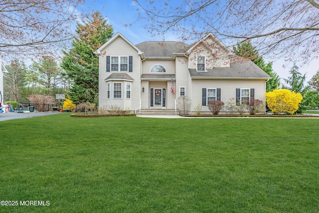 traditional-style home featuring a front yard and a shingled roof
