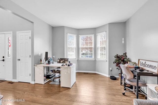 office space with visible vents, baseboards, and wood finished floors