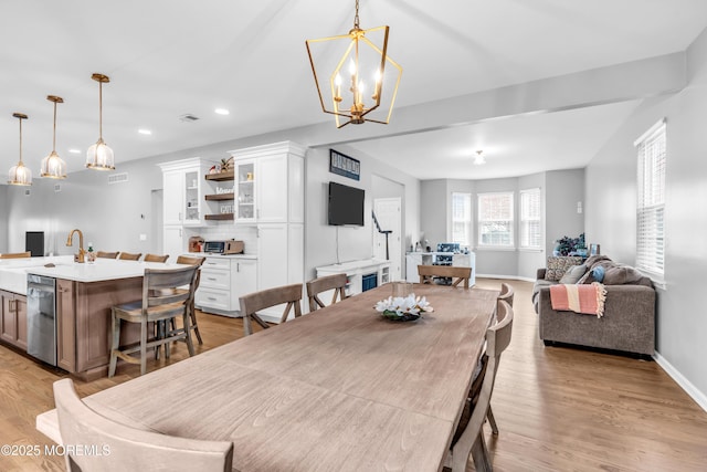 dining area with visible vents, recessed lighting, light wood finished floors, baseboards, and a notable chandelier