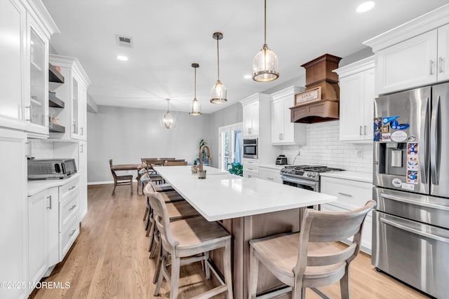 kitchen featuring white cabinets, visible vents, recessed lighting, stainless steel fridge, and decorative backsplash