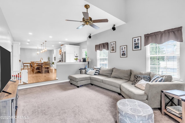 living room with light colored carpet, a ceiling fan, and recessed lighting