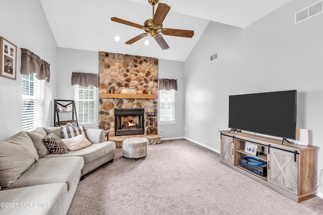 living area with visible vents, a wealth of natural light, a ceiling fan, and carpet floors