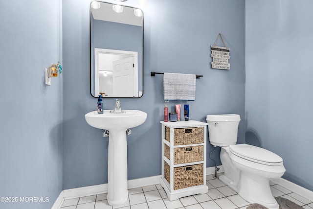 bathroom with tile patterned floors, baseboards, and toilet