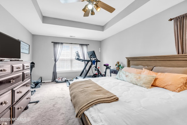 bedroom with carpet floors, baseboards, a ceiling fan, and a tray ceiling