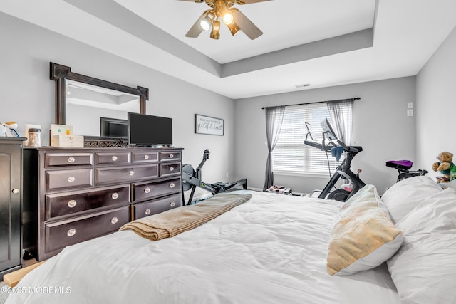 bedroom featuring visible vents, a ceiling fan, and a raised ceiling