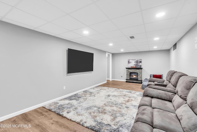 living area with a paneled ceiling, wood finished floors, visible vents, and recessed lighting