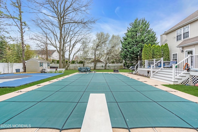 view of swimming pool with a patio, an outbuilding, a fenced backyard, and a deck