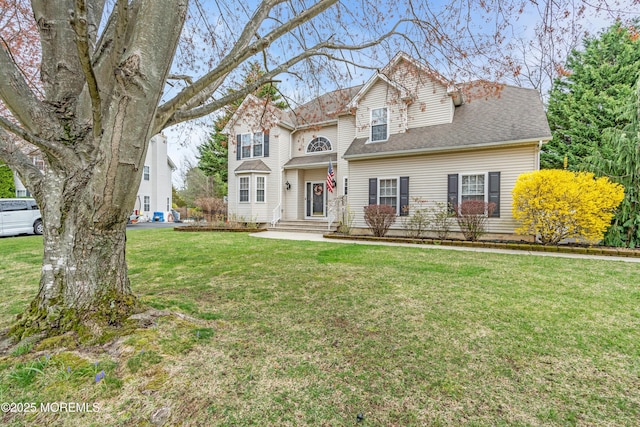 traditional-style house with a front yard and roof with shingles