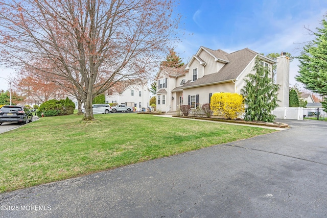 view of home's exterior featuring fence, a residential view, a lawn, and a chimney