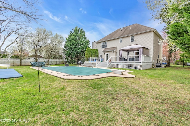 view of swimming pool with a fenced in pool, a yard, a fenced backyard, a wooden deck, and a gazebo
