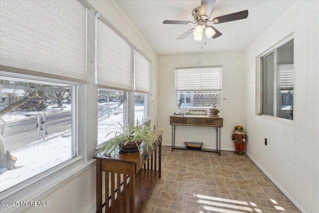 sunroom / solarium with plenty of natural light, baseboards, and stone finish flooring
