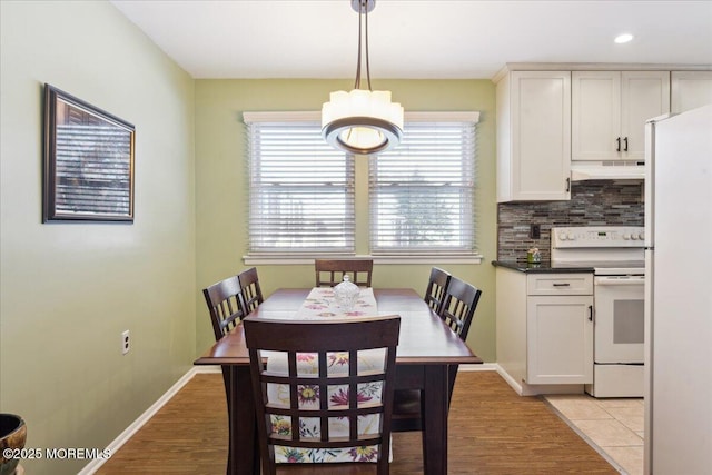 dining area with an inviting chandelier, light wood-type flooring, recessed lighting, and baseboards