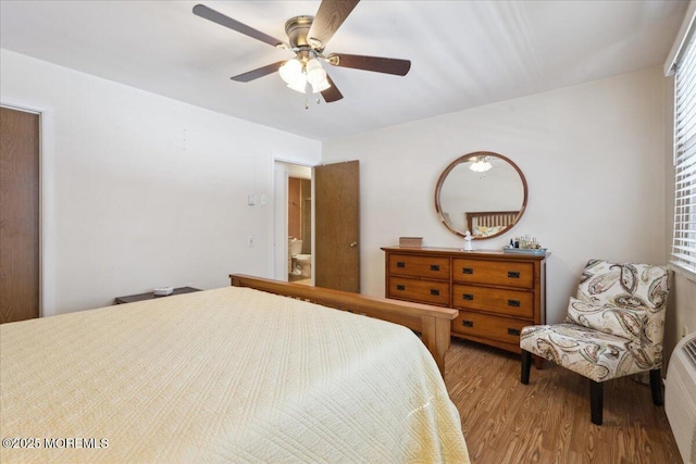 bedroom with a ceiling fan, multiple windows, and wood finished floors