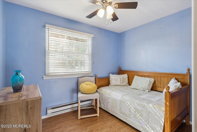 bedroom featuring ceiling fan, baseboards, wood finished floors, and a baseboard radiator