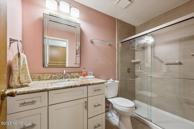 bathroom featuring vanity, toilet, and a stall shower