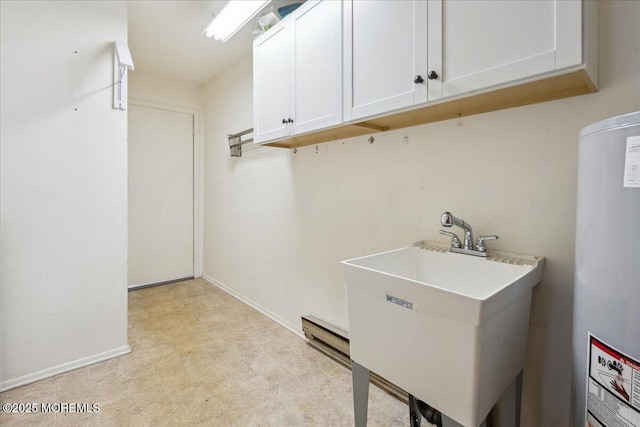 clothes washing area featuring baseboards, a sink, water heater, and light floors