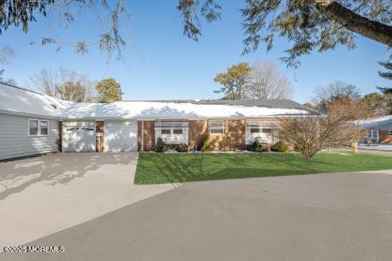 ranch-style home featuring driveway, a front lawn, and a garage