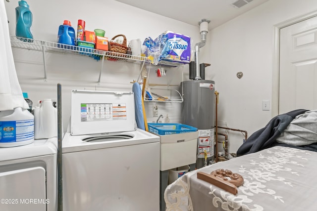 laundry room featuring visible vents, a sink, laundry area, washing machine and clothes dryer, and gas water heater