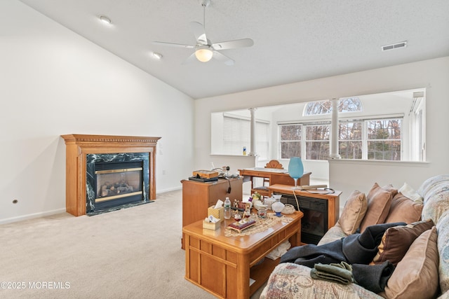 living room with a fireplace, light colored carpet, a ceiling fan, visible vents, and lofted ceiling