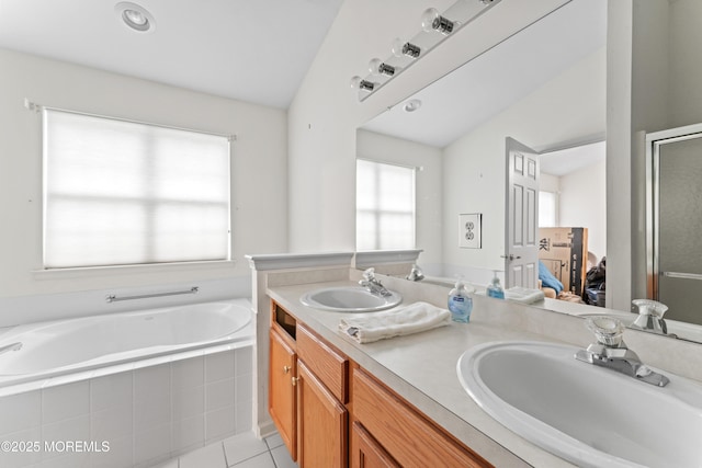 bathroom with a sink, tile patterned floors, a bath, and double vanity