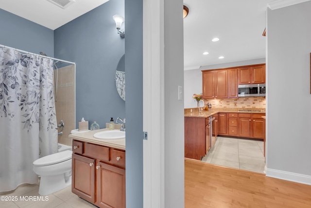 full bath featuring decorative backsplash, tile patterned floors, vanity, and shower / tub combo