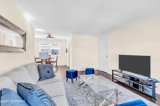 living area featuring a ceiling fan, wood finished floors, baseboards, and ornamental molding