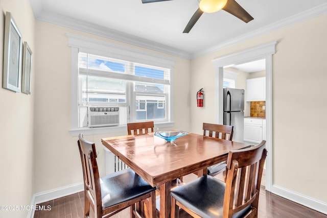 dining room with ornamental molding, dark wood-style flooring, baseboards, and a ceiling fan