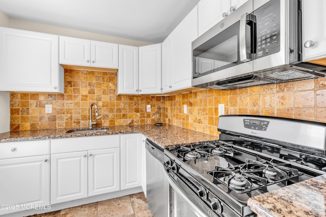 kitchen featuring light stone countertops, tasteful backsplash, a sink, and appliances with stainless steel finishes