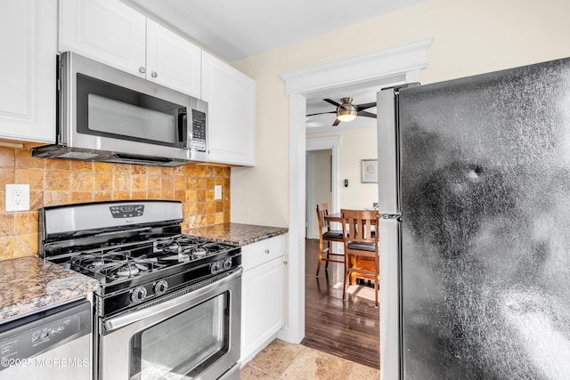 kitchen featuring white cabinets, ceiling fan, decorative backsplash, and stainless steel appliances