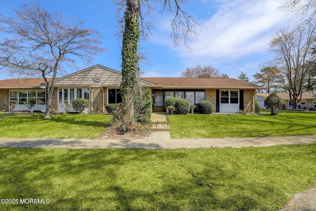 single story home with brick siding and a front yard
