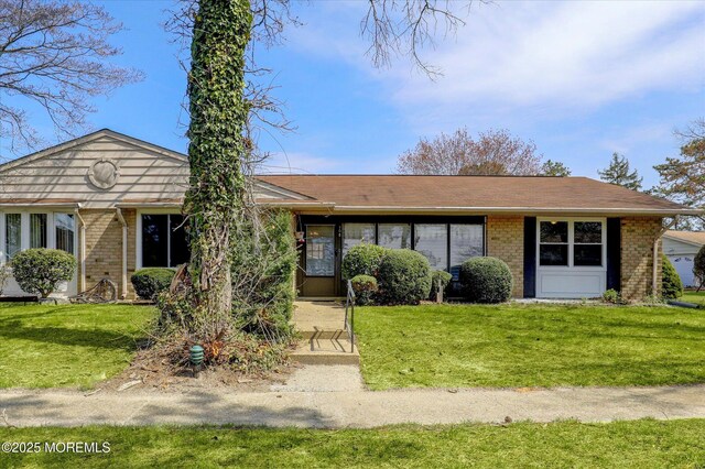 single story home featuring a front yard and brick siding