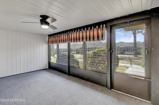 unfurnished sunroom with a ceiling fan and plenty of natural light