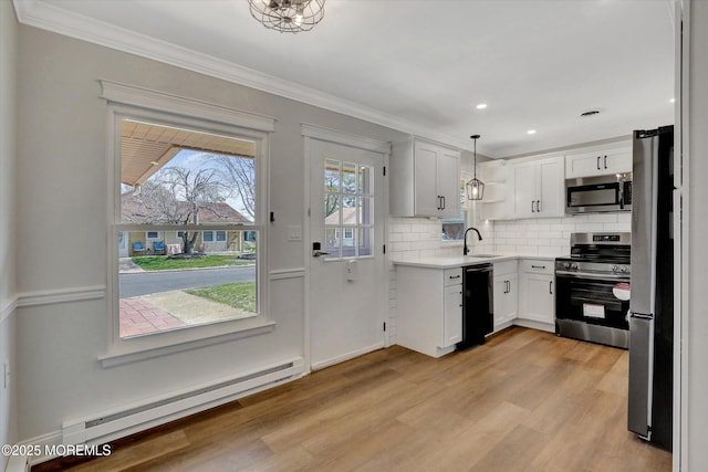kitchen featuring a sink, light wood-type flooring, a baseboard heating unit, and stainless steel appliances