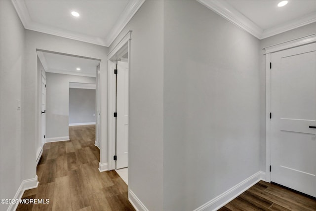 corridor featuring dark wood-style flooring, baseboards, and crown molding