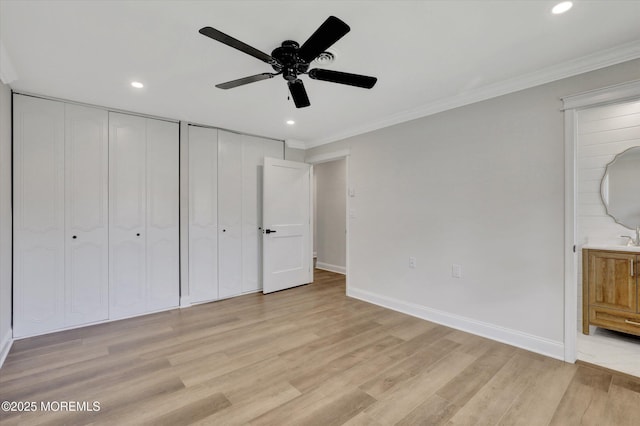 unfurnished bedroom with recessed lighting, light wood-style floors, baseboards, and multiple closets