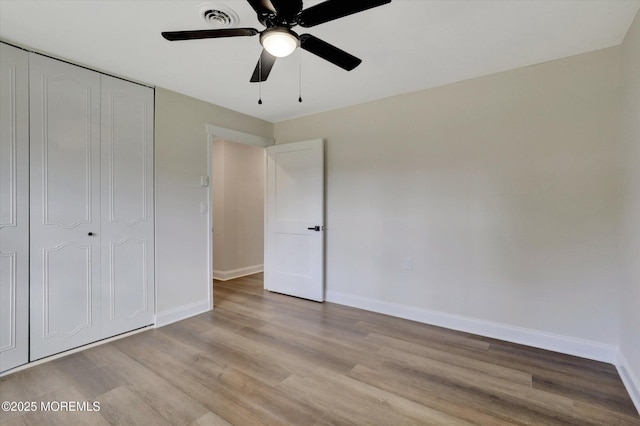unfurnished bedroom with visible vents, baseboards, a closet, ceiling fan, and light wood-type flooring