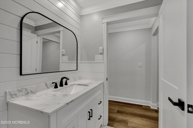 bathroom featuring crown molding, wood finished floors, vanity, and baseboards