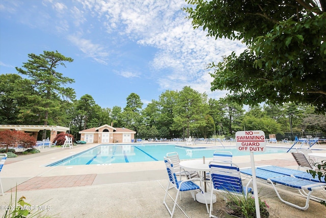 community pool with a patio and fence