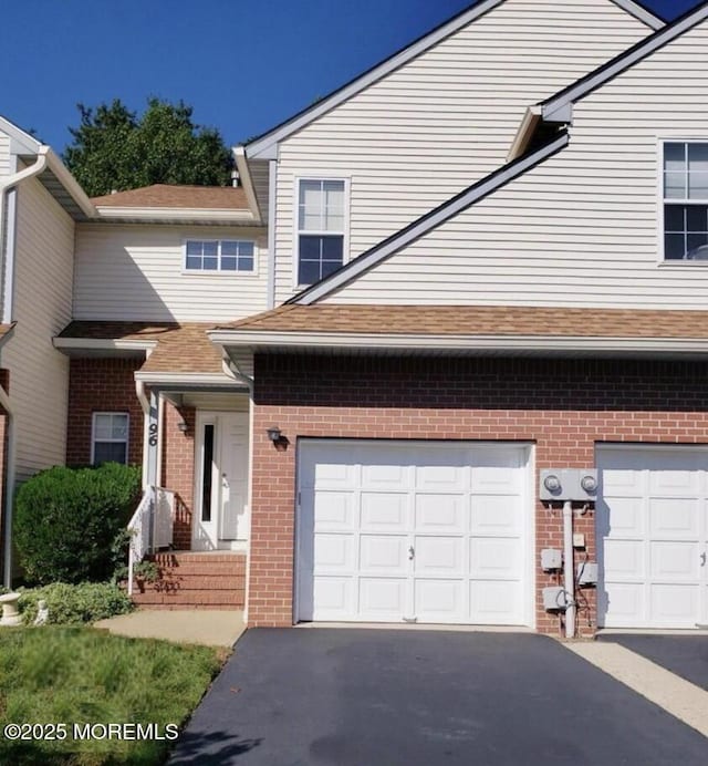 96 Drew Ct, Manalapan, NJ 07726 - view of front of home featuring brick siding, an attached garage, and aphalt driveway