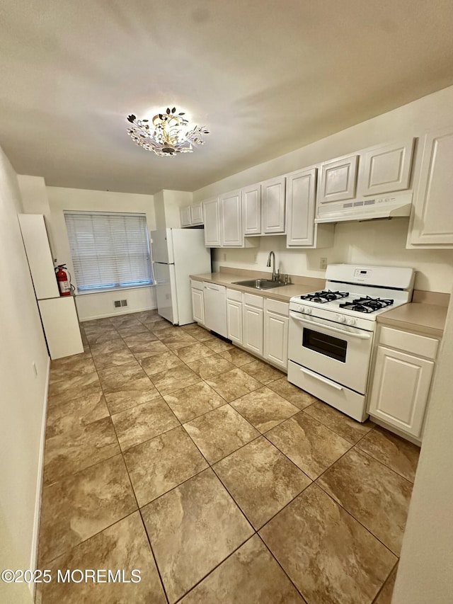 96 Drew Ct, Manalapan, NJ 07726 - kitchen with white appliances, light countertops, white cabinetry, under cabinet range hood, and a sink