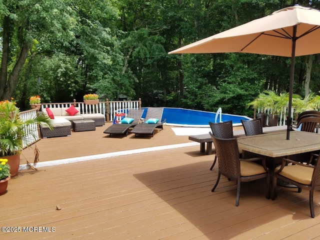 pool with an outdoor hangout area, outdoor dining space, and a deck
