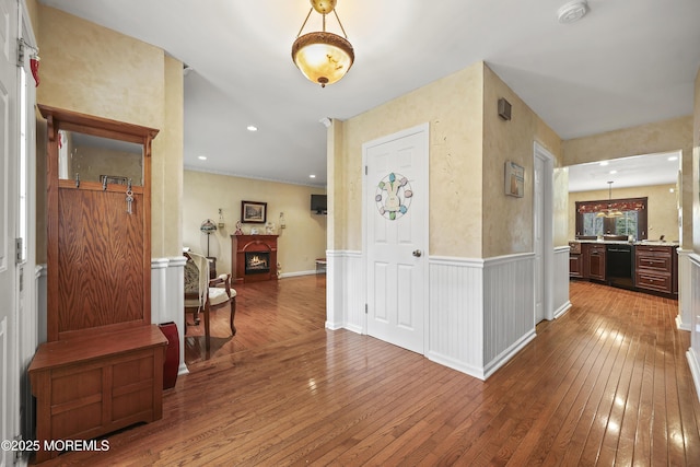hall featuring wood-type flooring and an inviting chandelier