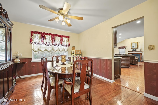 dining space with hardwood / wood-style flooring, a wainscoted wall, and plenty of natural light