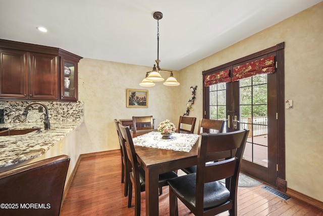 dining area featuring light wood-style flooring, visible vents, baseboards, and french doors