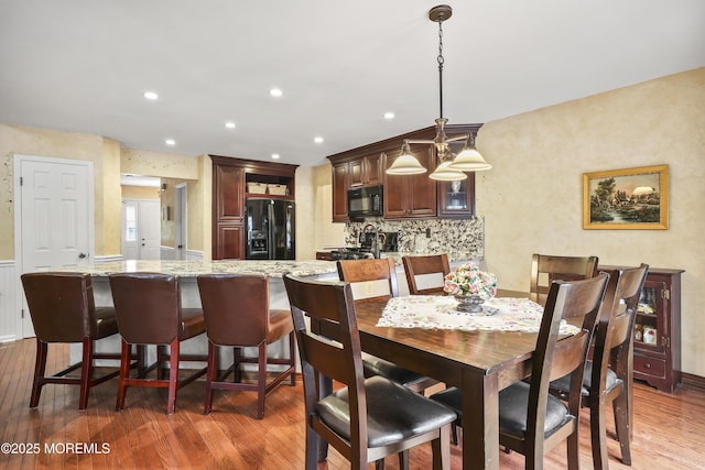 dining area featuring light wood finished floors and recessed lighting