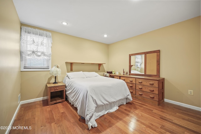 bedroom with wood-type flooring, baseboards, and recessed lighting