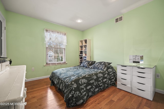 bedroom featuring hardwood / wood-style flooring, baseboards, and visible vents