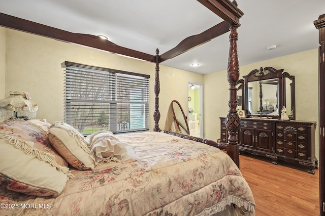 bedroom featuring wood finished floors and ensuite bathroom