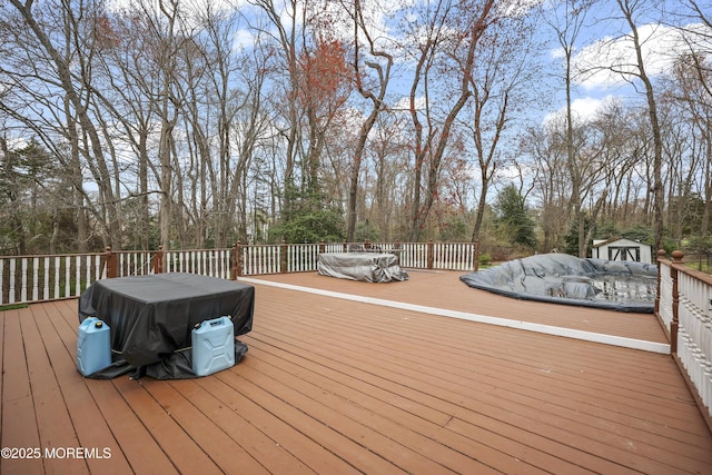 wooden deck with an outdoor structure and a shed